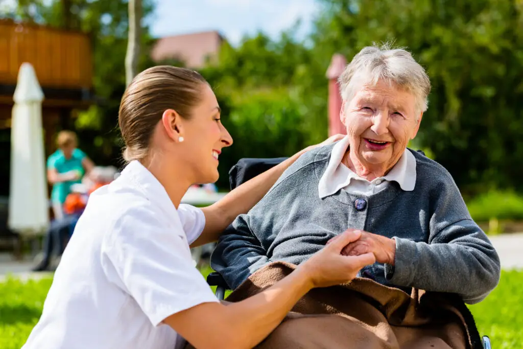 Caregiver assisting a senior in a wheelchair with compassionate home care services in Adrian, MI